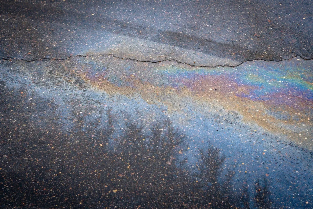 Ölspur mit Regenbogenschimmer auf Asphalt