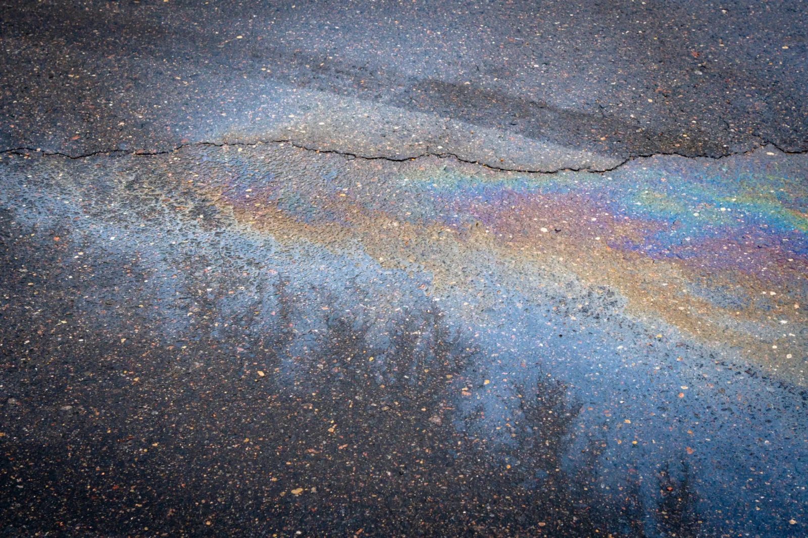 Ölspur mit Regenbogenschimmer auf Asphalt